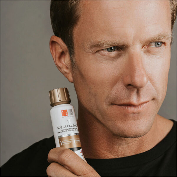 hombre posando junto un envase de Spectral.DNC-N 60ml