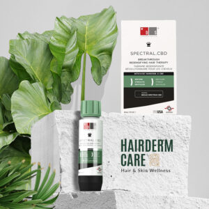 Tratamiento anticaída de pelo Spectral DNC-N tanto para hombres como para mujeres, destacando su envase de 60ml y su caja rodeado de un entorno natural de piedra y hojas verdes en el fondo.