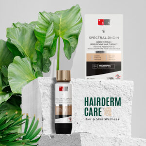 Tratamiento caída de pelo Spectral DNC-N tanto para hombres como para mujeres, destacando su envase de 60ml y su caja rodeado de un entorno natural de piedra y hojas verdes en el fondo.